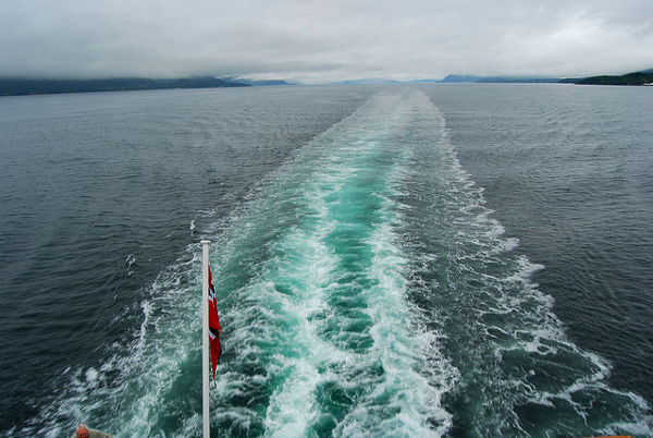 Estela del Hurtigruten en el fiordo Feiranger