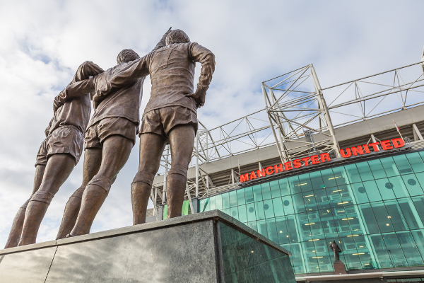 Old Trafford en Manchester, estatua de Best, Law y Charlton